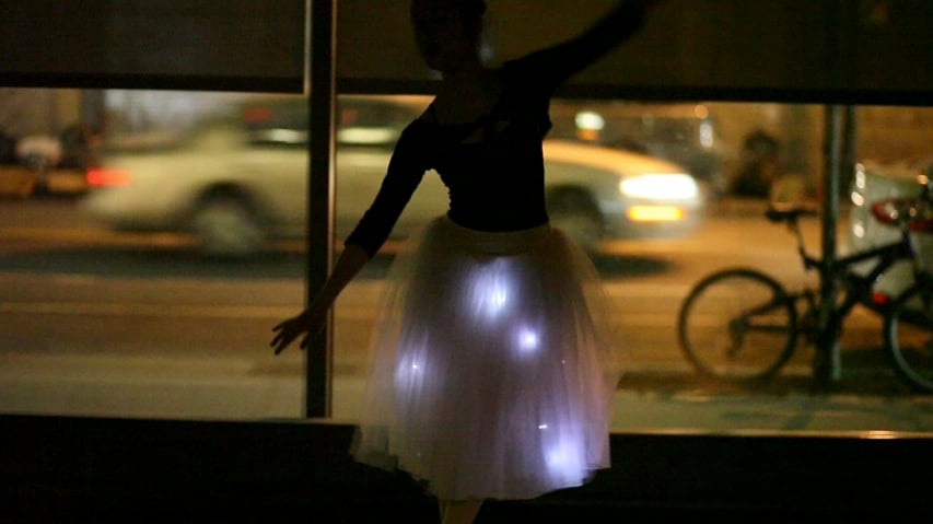Silhouetted woman wearing a skirt with LED embedded in it